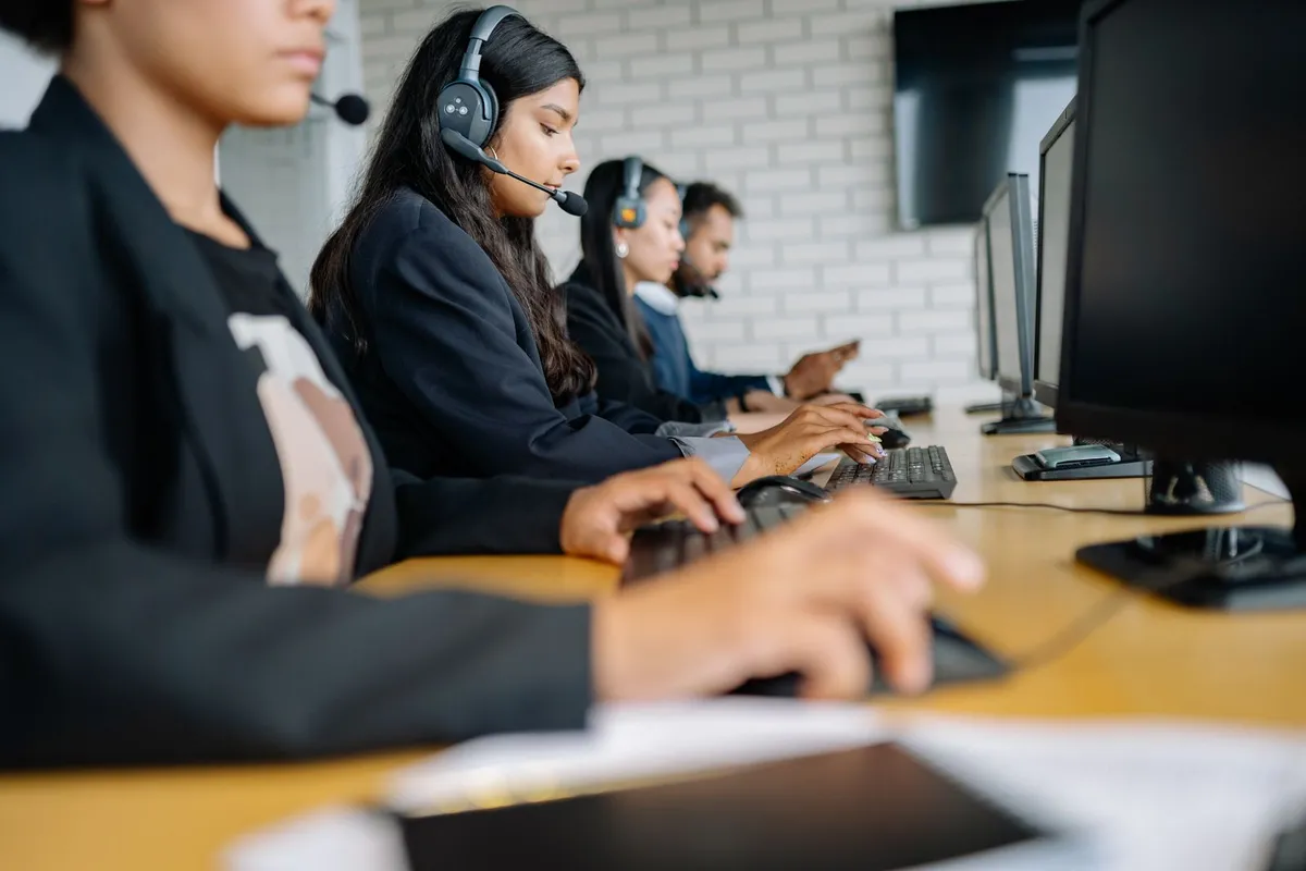 A customer support team wearing headsets in a modern office, ready for chatbot hand-offs