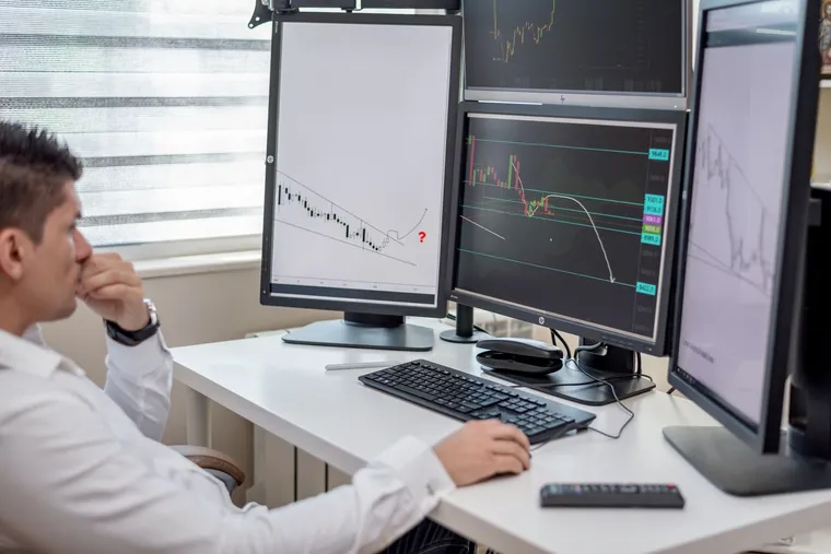 A data analyst reviewing a database across multiple monitors — Avaib