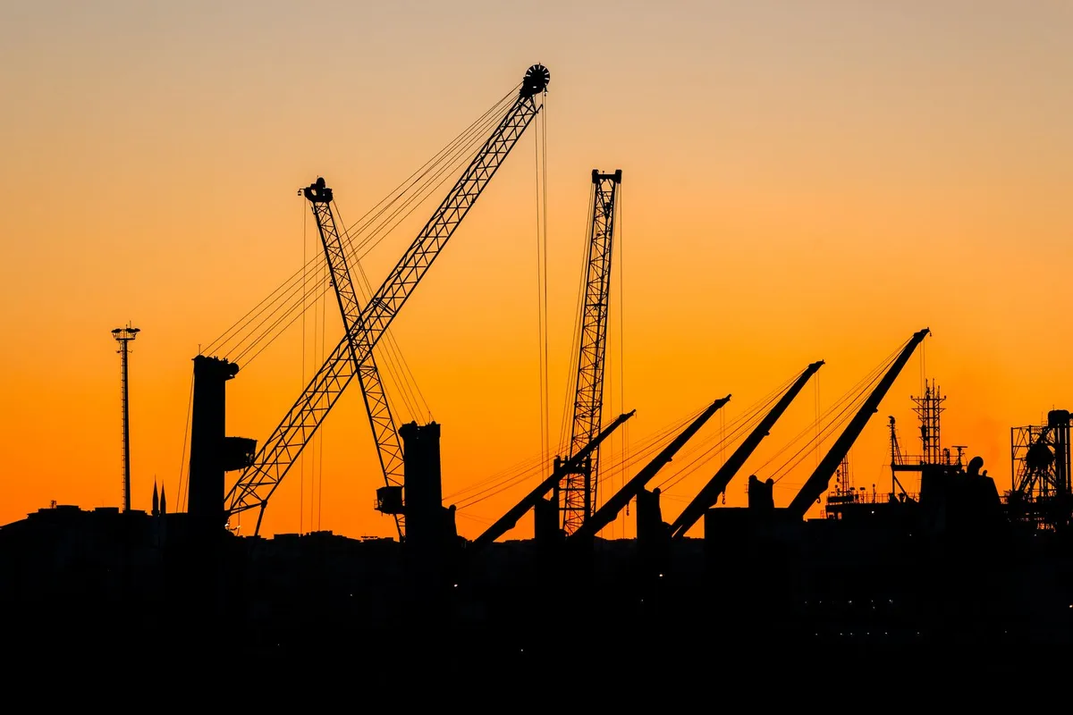 Tower cranes over a construction site at dusk