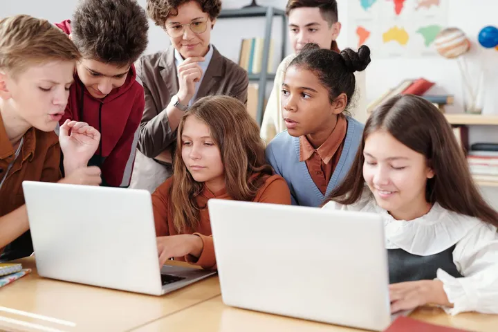 Students learning together on laptops in a classroom — Avaib