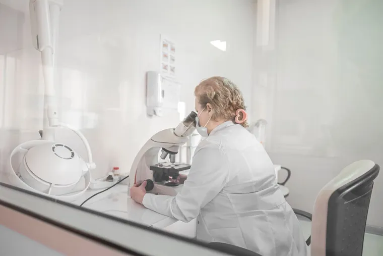A laboratory researcher working at a microscope — Avaib