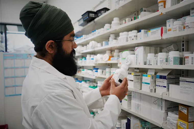 A pharmacist in front of shelves of medication — Avaib