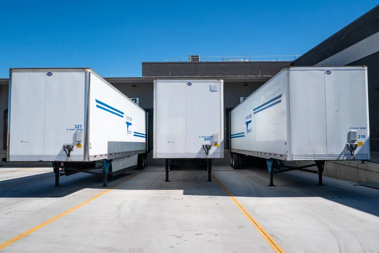 A fleet of delivery trucks at a loading dock — Avaib