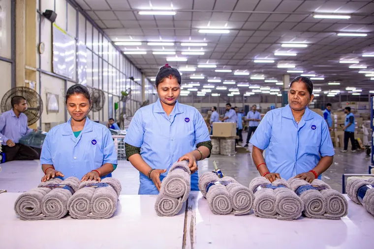 Workers inspecting products for quality on a factory floor — Avaib