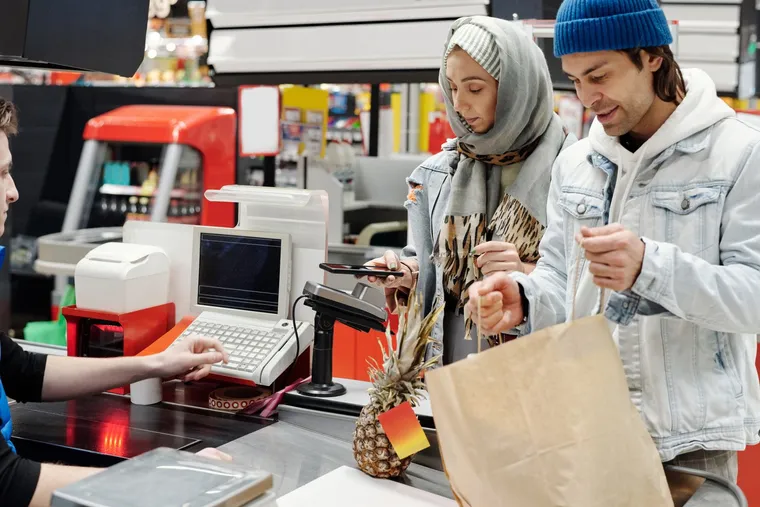 A customer paying at a store checkout counter — Avaib