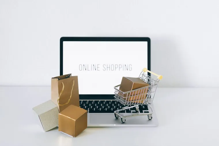 Online shopping with a parcel beside a laptop — Avaib