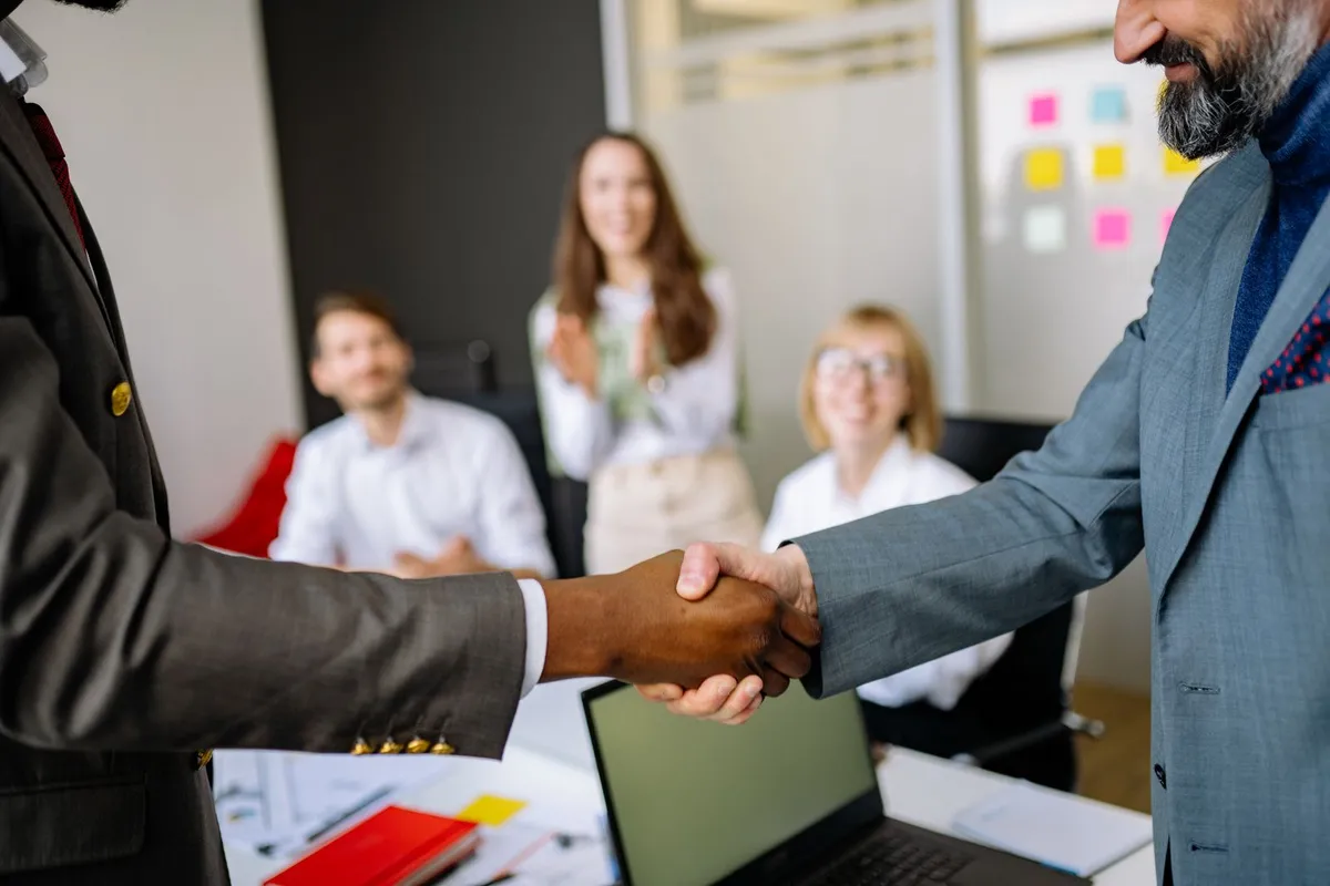 Business partners shaking hands at a meeting in a modern office