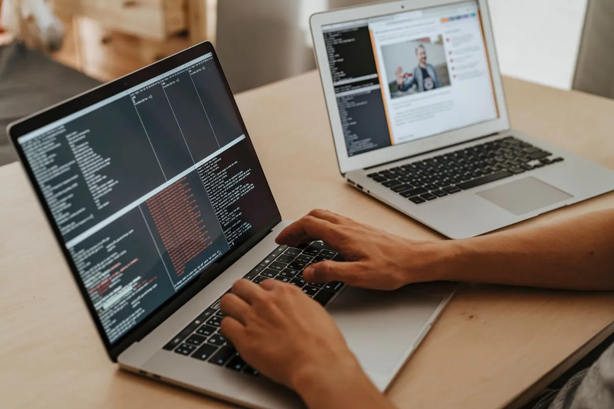 A senior developer writing software on a laptop
