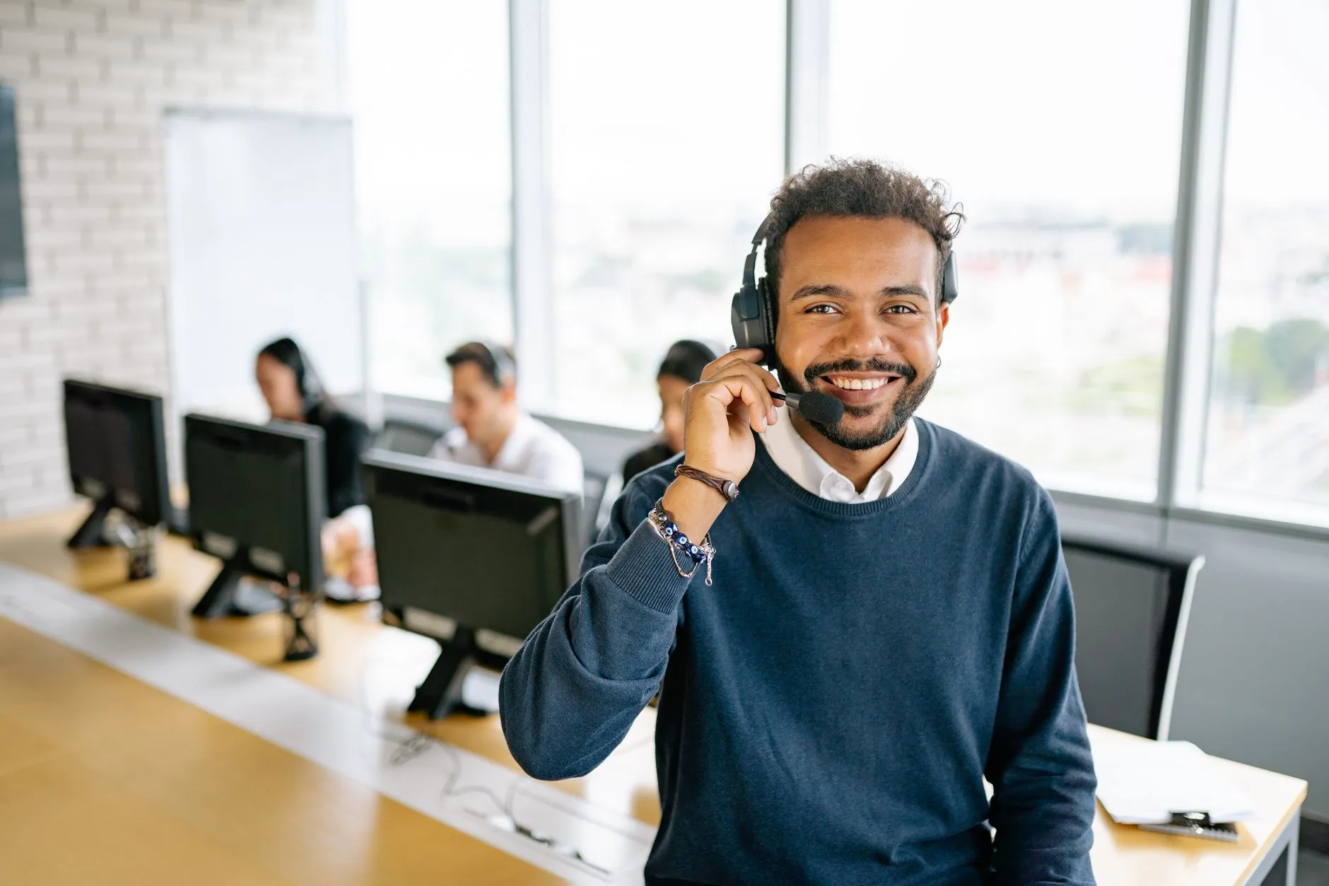 A business professional making an outbound scheduling call at a desk — Avaib